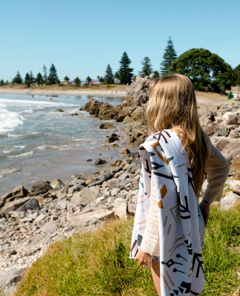 MAHĀNA Wanderer beach towel in use at the beach – sand-free and super absorbent microfibre towel